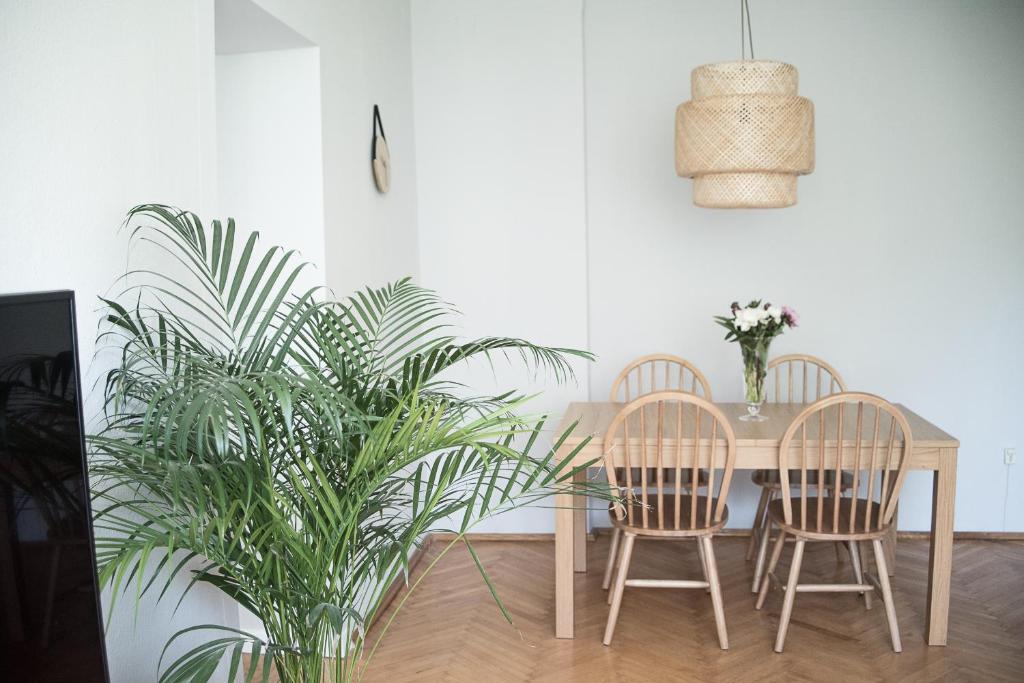 a dining room table with two chairs and a plant at TS City Centre Apartment in Szczecin