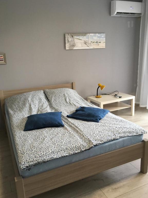 a bedroom with a bed with blue pillows on it at Bolero in Dziwnówek