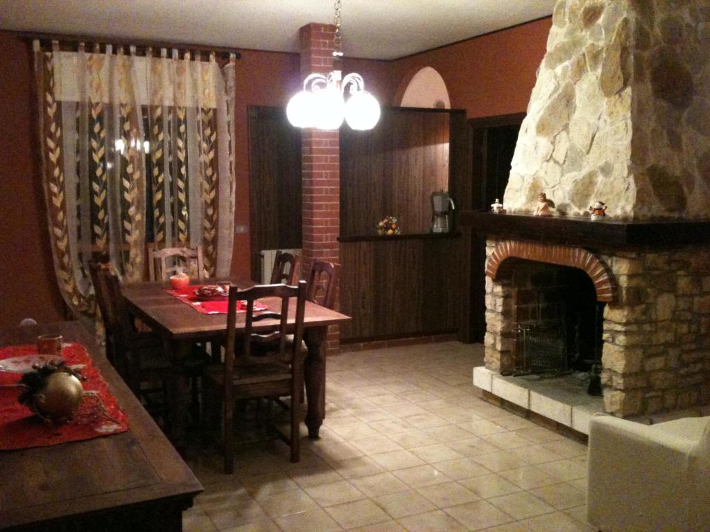a living room with a table and a fireplace at Residence ELIOS in Caramanico Terme