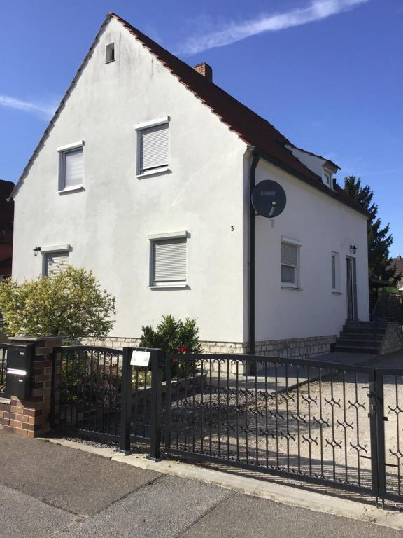 a white house with a black fence at Ferienwohnung Elina in Maxhütte-Haidhof