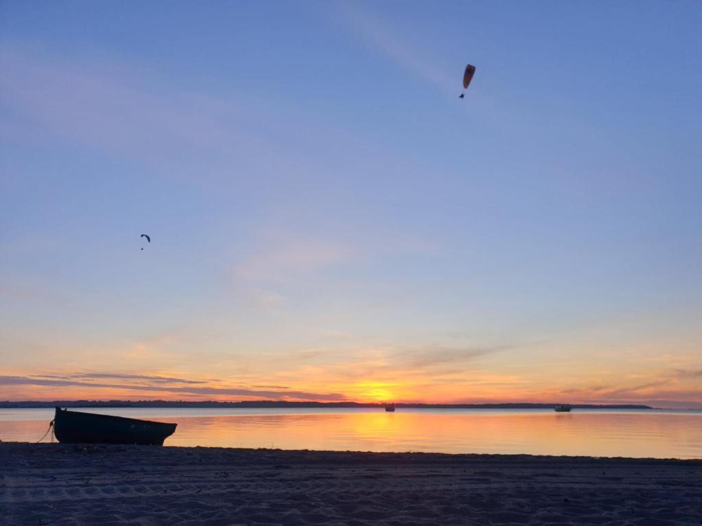 un barco sentado en la playa al atardecer en Zakotwiczeni, en Rewa