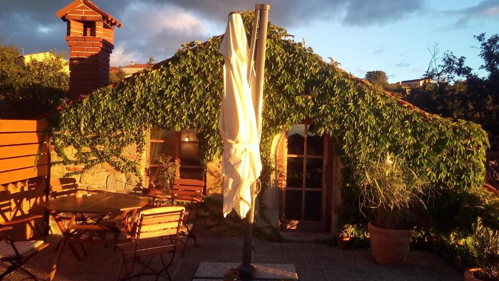 une terrasse avec un parasol, une table et des chaises dans l'établissement Istria Divina, à Marezige