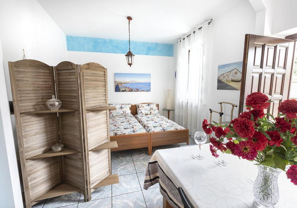 een slaapkamer met een bed en een tafel met een vaas met bloemen bij La Corte in Rescaldina