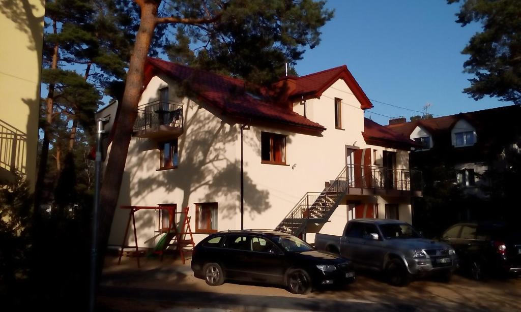 a house with a car parked in front of it at Kama Apartament Pobierowo in Pobierowo