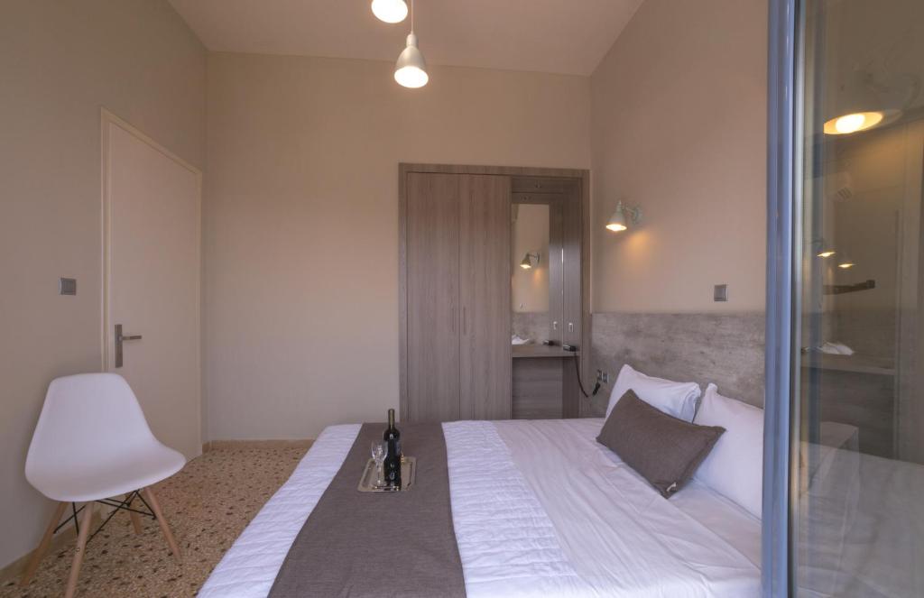 a bedroom with a bed with a chair and a window at Vivari Acta in Vivari