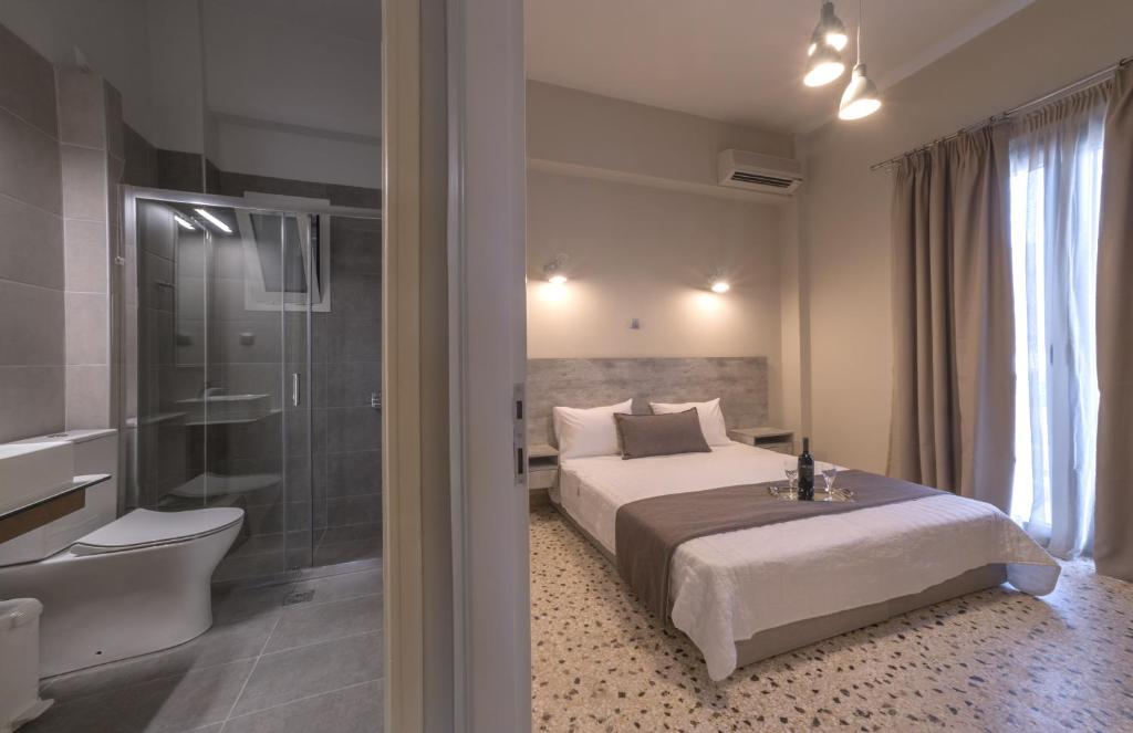 a bedroom with a bed and a bathroom with a shower at Vivari Acta in Vivari