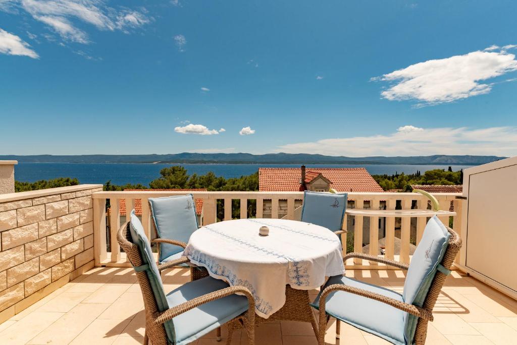 a table and chairs on a balcony with a view of the water at Apartments Kristian in Bol