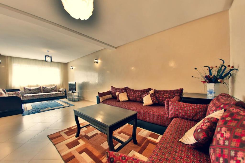 - un salon avec un canapé rouge et une table dans l'établissement Amazing New Central Apartment, Modern, very Clean and very Comfortable, à Rabat
