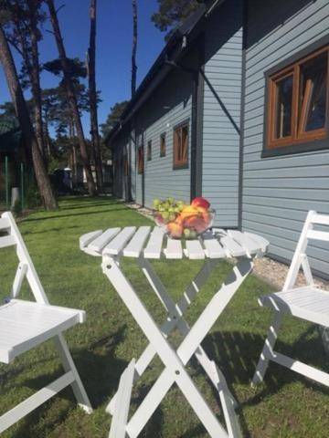 a white picnic table with a toy on top of it at Domki ALEX przy plaży in Dziwnówek