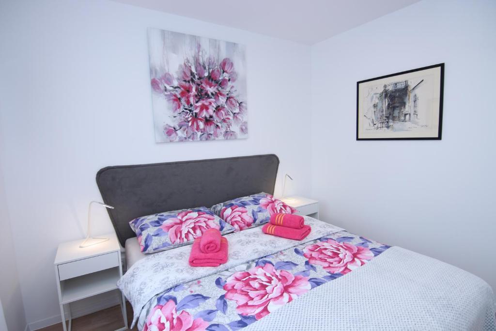 Un dormitorio con una cama con flores rosas. en Prestige West Residence, en Zagreb
