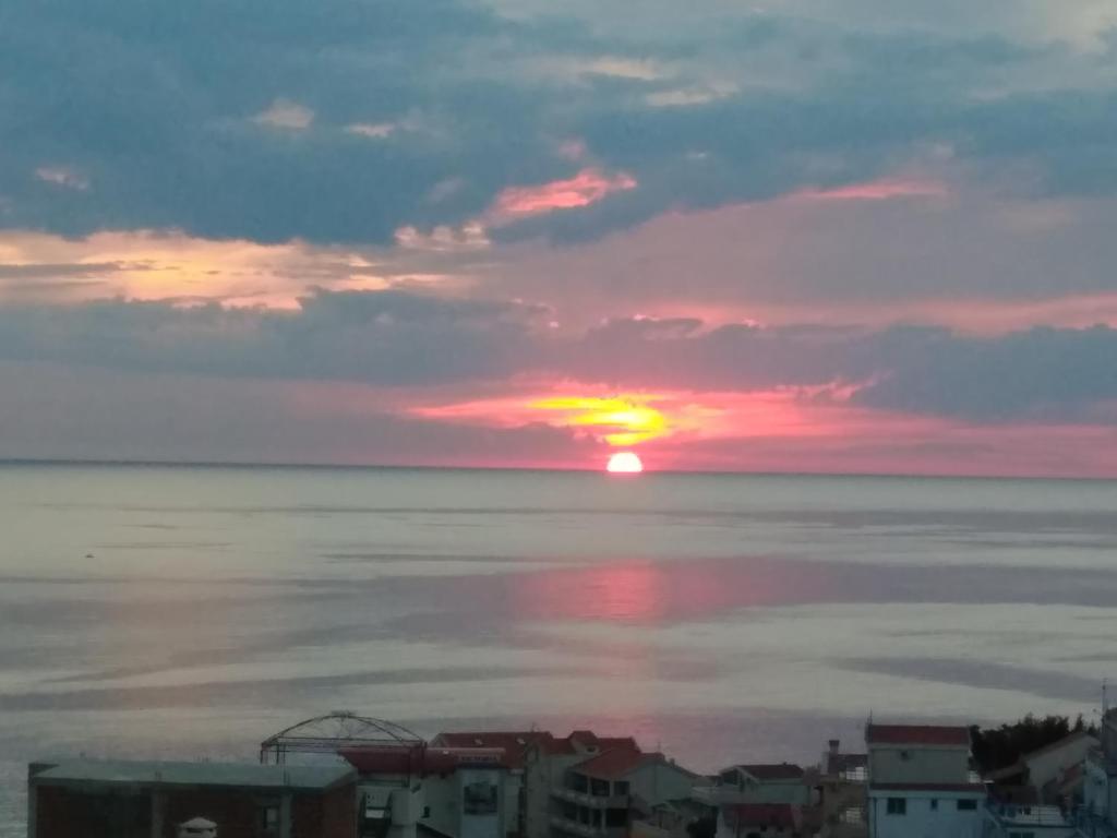a sunset over the ocean with the sun in the sky at Apartments Svetlana in Utjeha