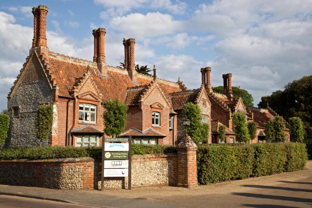 an old brick house with a sign in front of it at Victoria in Holkham