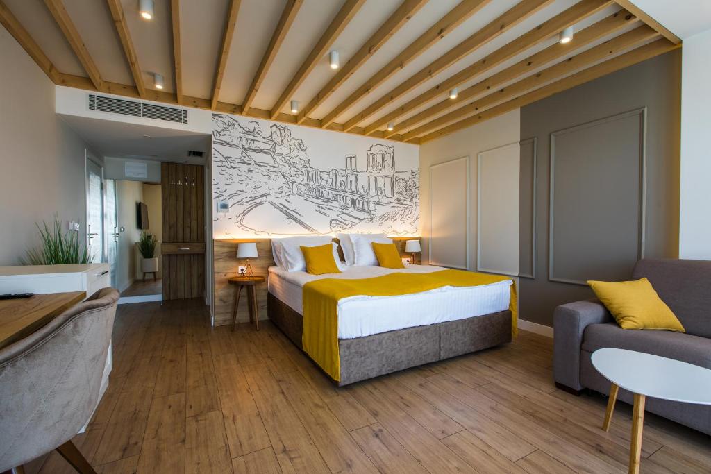 pokój hotelowy z łóżkiem i kanapą w obiekcie HillHouse Plovdiv w Płowdiwie