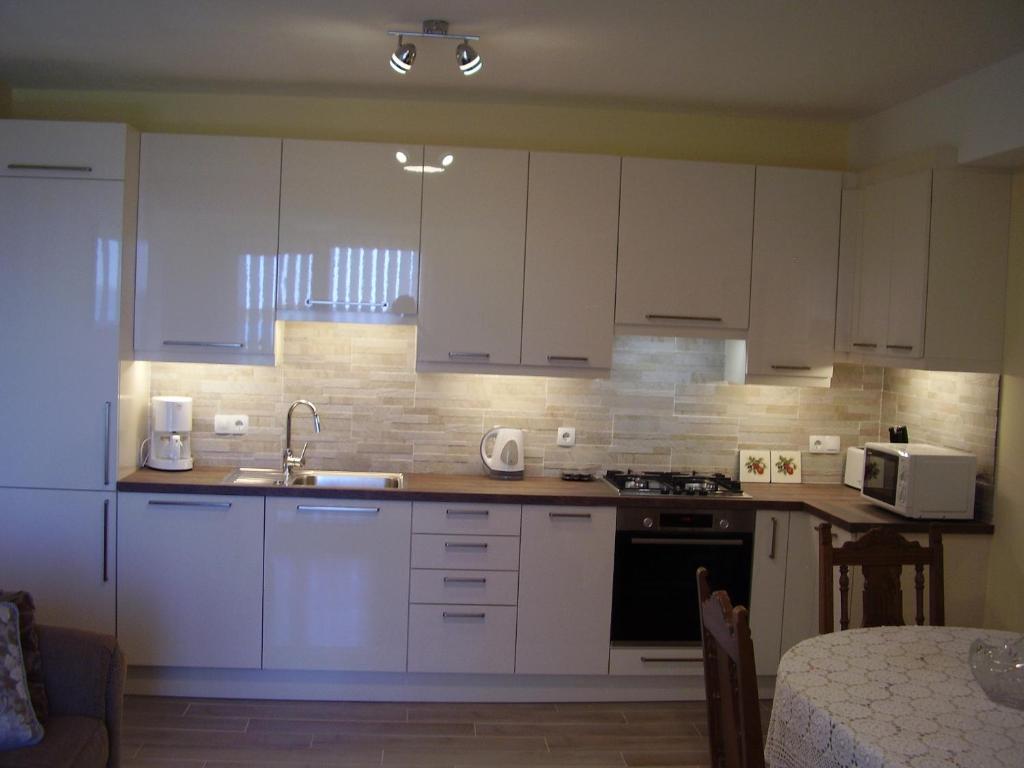 a kitchen with white cabinets and a sink at Water view brand new Apartment, short stroll to beach, peaceful! in Košljun