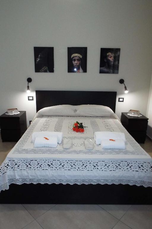 a bedroom with a large bed with two tables at Cefalù Studio Room and Apartments in Cefalù