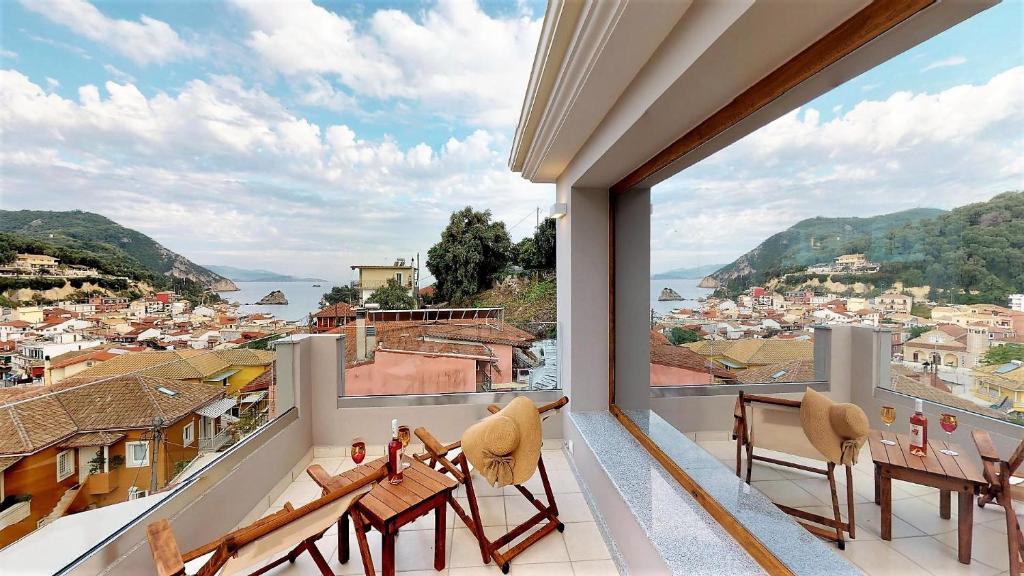 a balcony with chairs and a view of a city at Parga Inn Suites in Parga