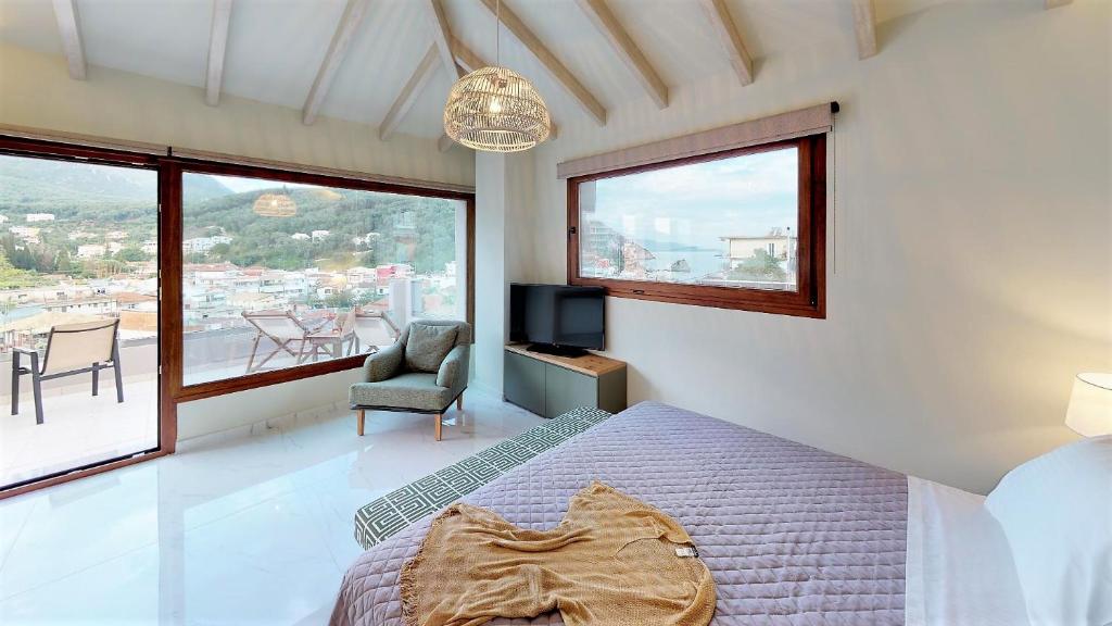 a bedroom with a bed and a tv and a window at Parga Inn Suites in Parga