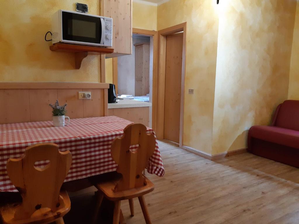 a kitchen with a table and a tv on the wall at Casa Anita in Livigno