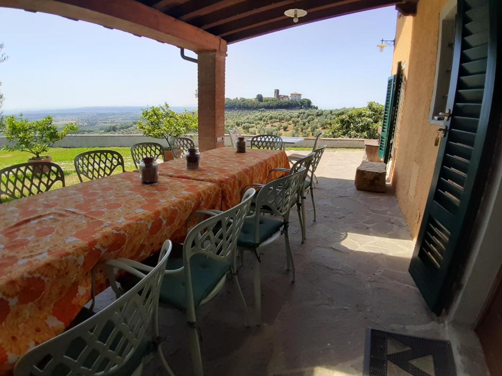 une table et des chaises sur une terrasse avec vue dans l'établissement Villa Pilar in Toscana con piscina ultrapanoramica, à Montevettolini