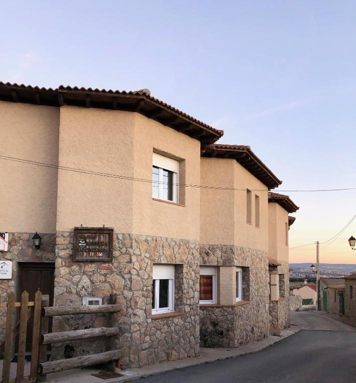 a stone house with a fence in front of it at Casas Encinares in Narrillos de San Leonardo
