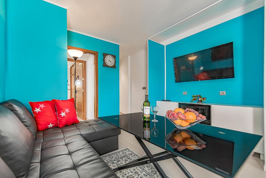 ein Wohnzimmer mit einem Sofa und einem Tisch mit einer Obstschale in der Unterkunft Apartamento nuevo en Alcalá, con aparcamento, con aircondicionador in Alcalá