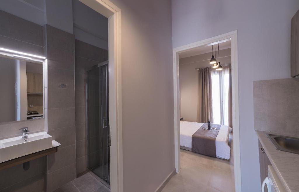 a bathroom with a sink and a bed and a mirror at Vivari Acta in Vivari