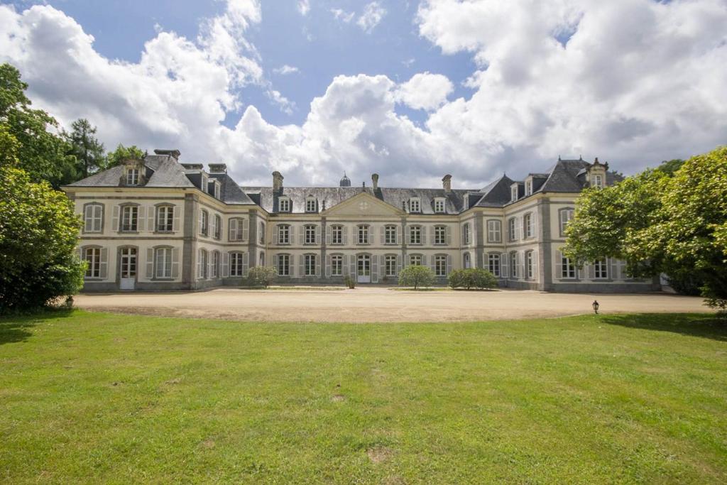 uma casa grande com um grande quintal em frente em Château de Lannouan em Landévant