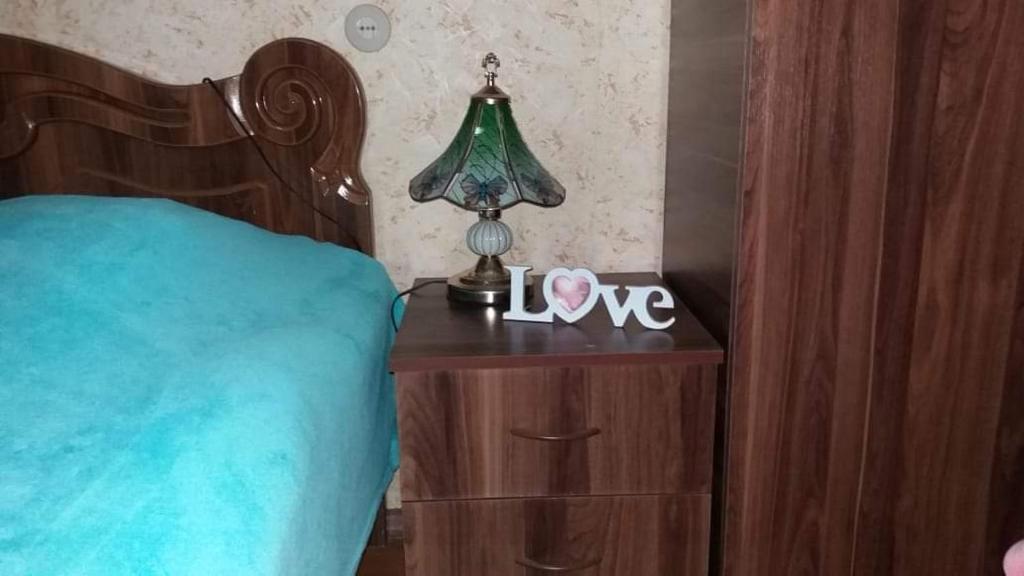 a bedroom with a bed and a lamp on a night stand at Victoria in Bagdatʼi