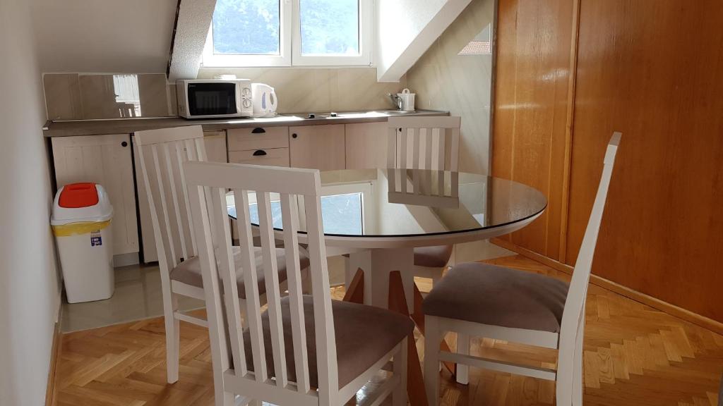 a small kitchen with a table and two chairs at Apartmani Kovačević in Kotor