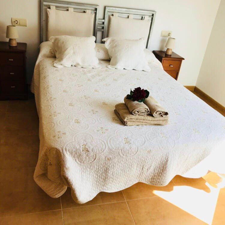 ein Bett mit zwei Handtüchern und Schuhen darauf in der Unterkunft La Caixeta in Vinarós