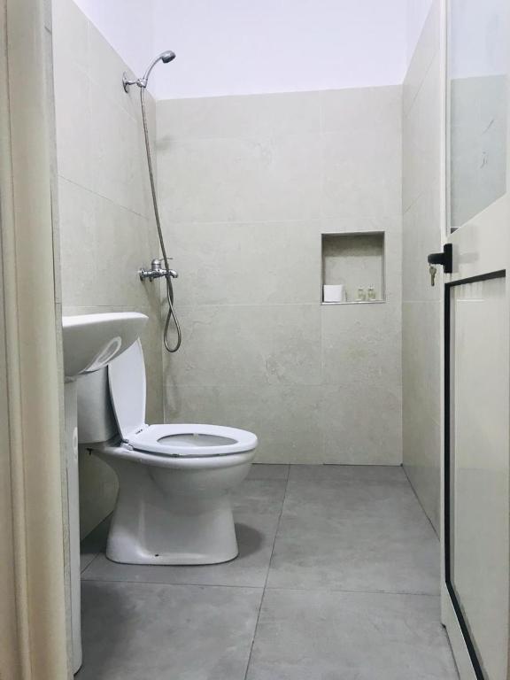 a bathroom with a white toilet and a sink at Sea Front Villa in Vlorë