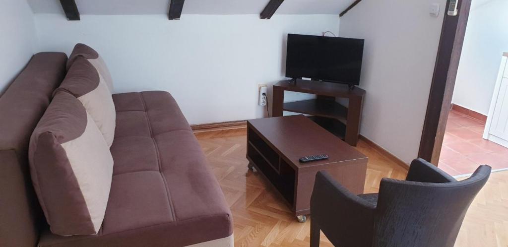 a living room with a couch and a tv at Apartmani Kovačević in Kotor