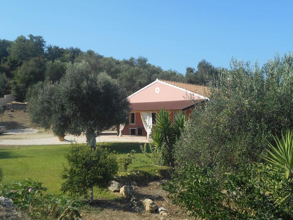 a house with a garden and trees in front of it at Myrto's House in Vouniatádes