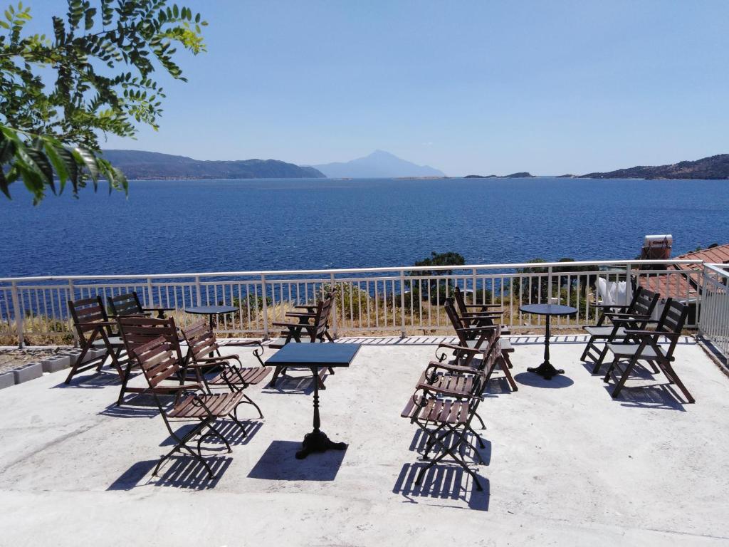 un gruppo di sedie e tavoli con vista sull'acqua di Villa Elli ad Ammouliani