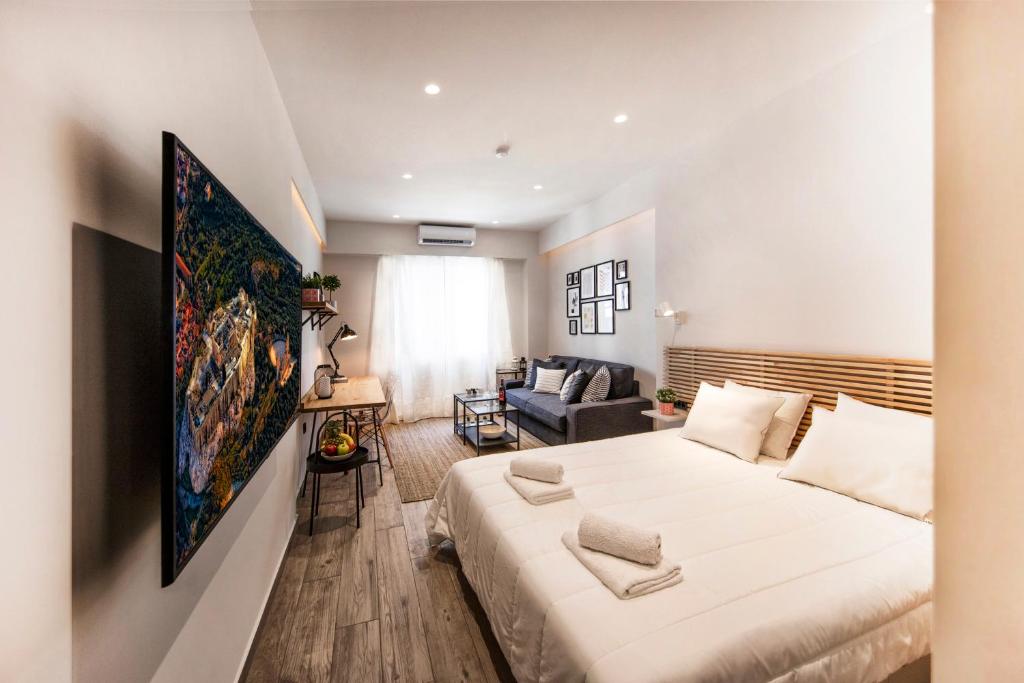 a bedroom with a large bed and a living room at Downtown Syntagma apartment 3 in Athens