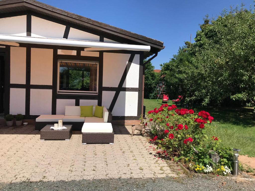 a house with a couch and flowers in the yard at Lili´s Bungalow auf der Halbinsel Scheid in Waldeck