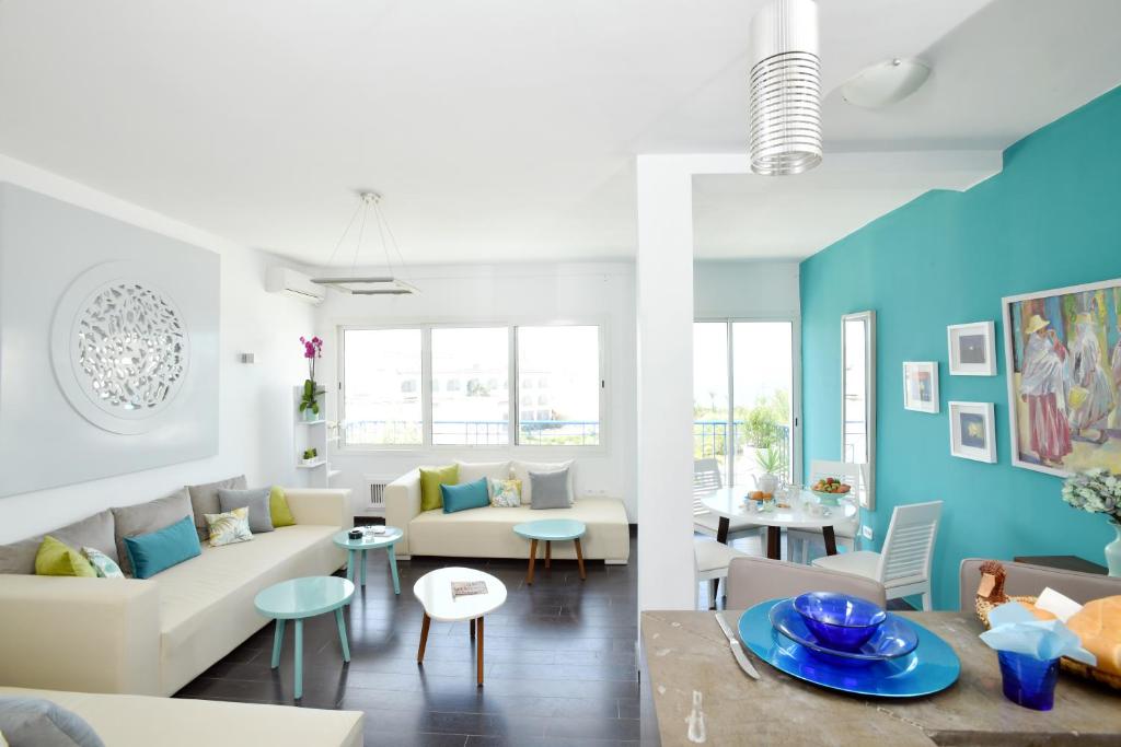 Le Turquoise في قمرت: غرفة معيشة مع أريكة بيضاء وجدران زرقاء