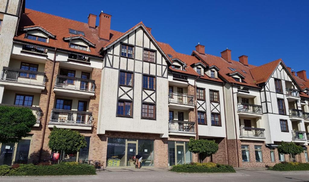 a large building with a red roof at Apartments Bulwar Portowy in Ustka