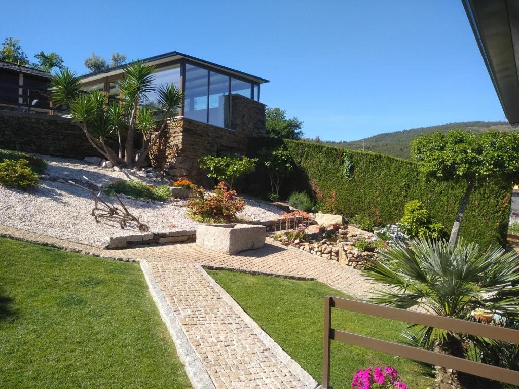 a garden with a house with a glass at Canastro Country House in Castelo de Paiva