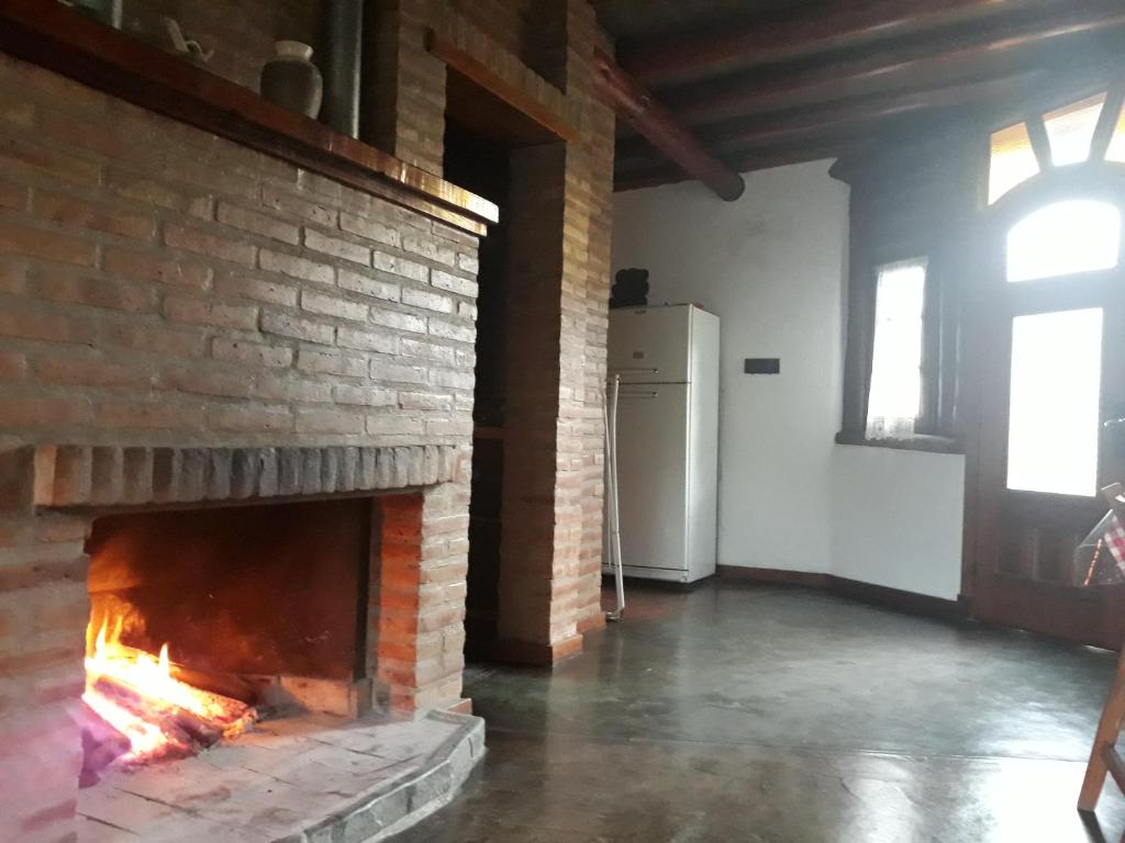 a brick fireplace in a room with a window at Cabañas Entrelomas in Nono