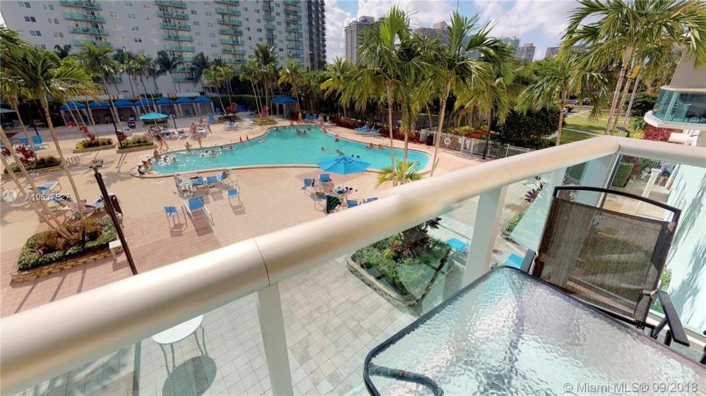 uma vista para uma piscina a partir de uma varanda em Sunny Isles Condo Resort em Miami Beach