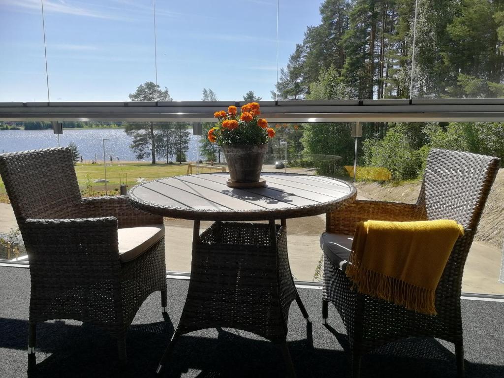 a table and chairs with a vase of flowers on it at Feels like Home Helmi in Jyväskylä