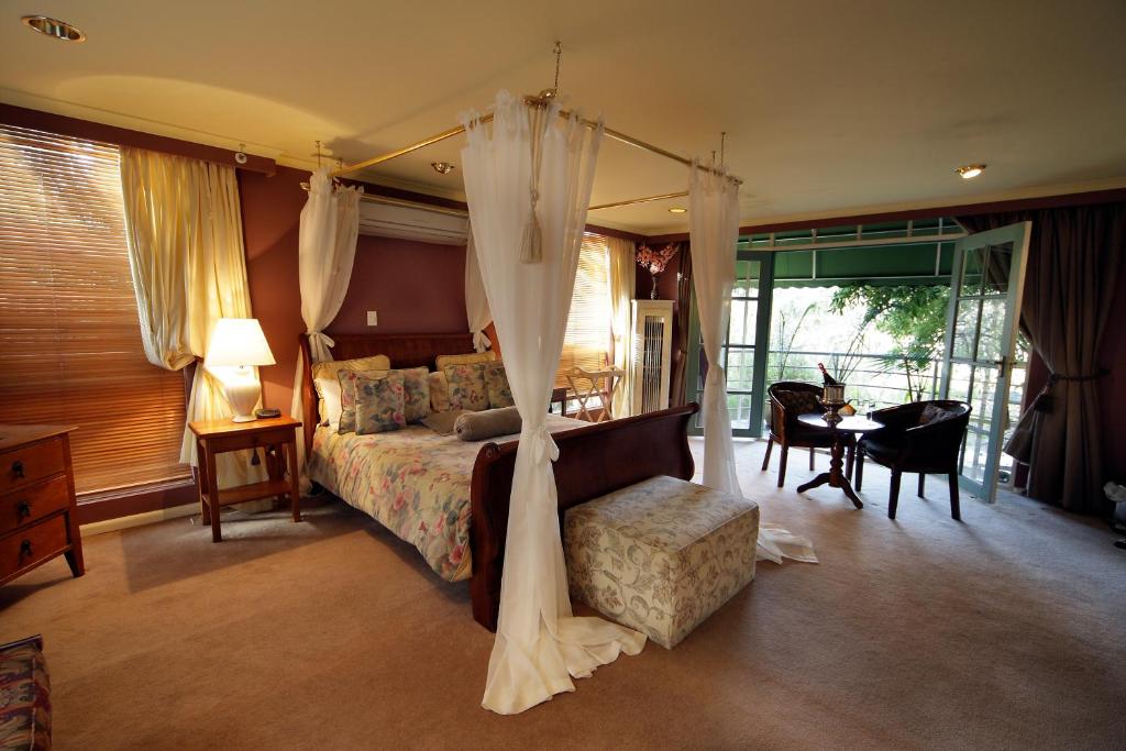 a bedroom with a canopy bed and a table and chairs at The Castle - Villa by the Sea in Cowes