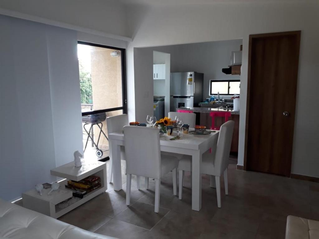 a dining room with a white table and white chairs at Reserva de la Colina in La Tebaida