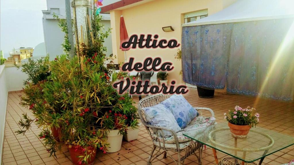 einen Stuhl, einen Glastisch und einige Pflanzen in der Unterkunft Guest House Attico Della Vittoria in Gabicce Mare