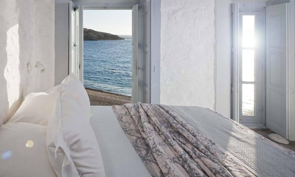 1 dormitorio con 1 cama y vistas al océano en Coco-Mat Eco Residences Serifos, en Vayiá