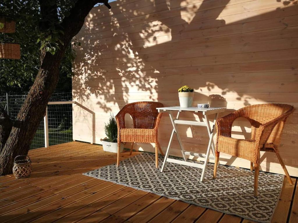 two chairs and a table on a deck at Fűszerkert vendégház in Zamárdi