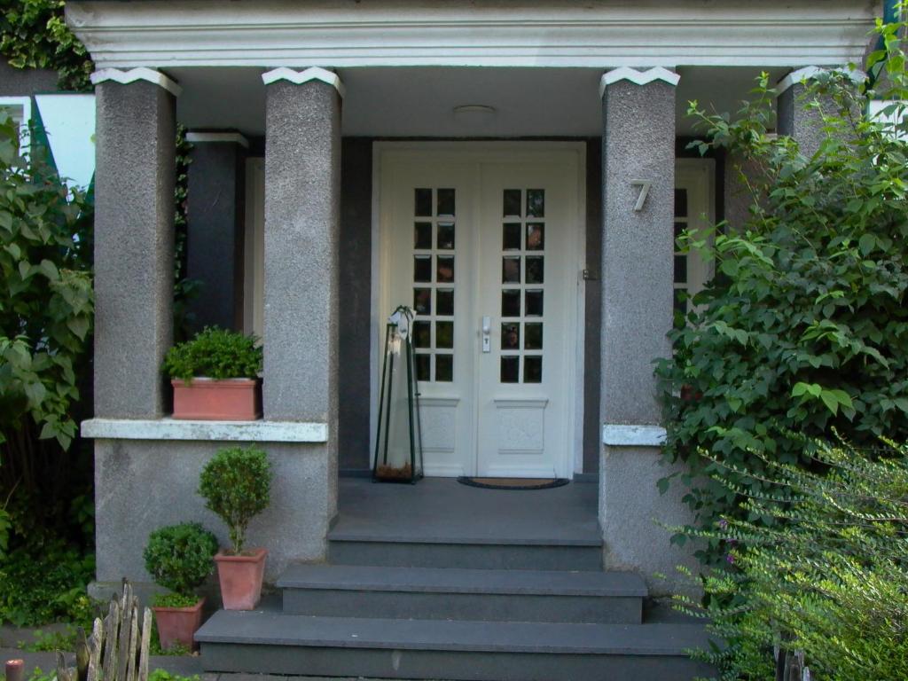 una casa con porta bianca e scale di Altes Landhaus am Park a Xanten