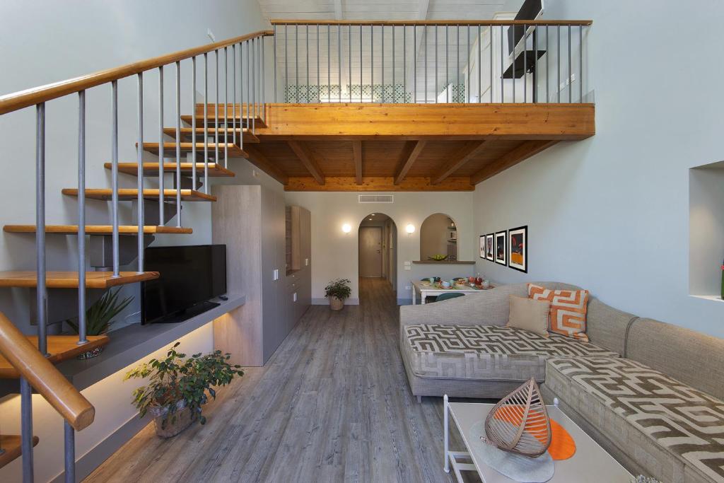 a living room with a staircase and a couch at Amore Rentals - Casa La Maisonette in Sorrento