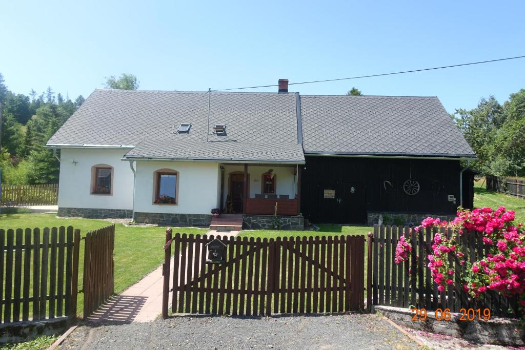 een wit huis met een hek en roze bloemen bij ČAKOVÁ 116 in Čaková